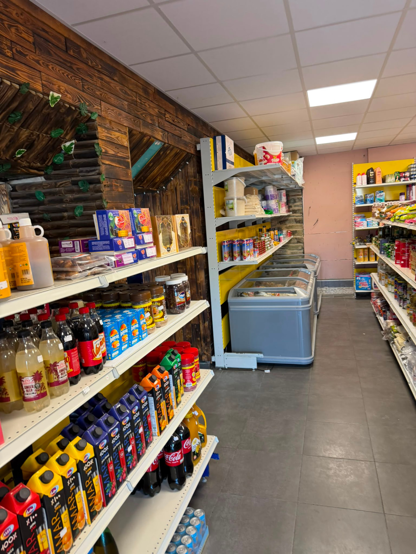 Allée principale et rayons garnis de l'épicerie N MARKET